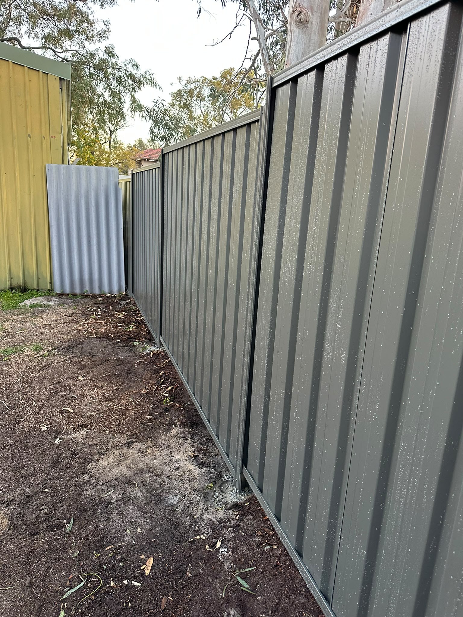 Grey Colorbond fence following a narrow residential boundary